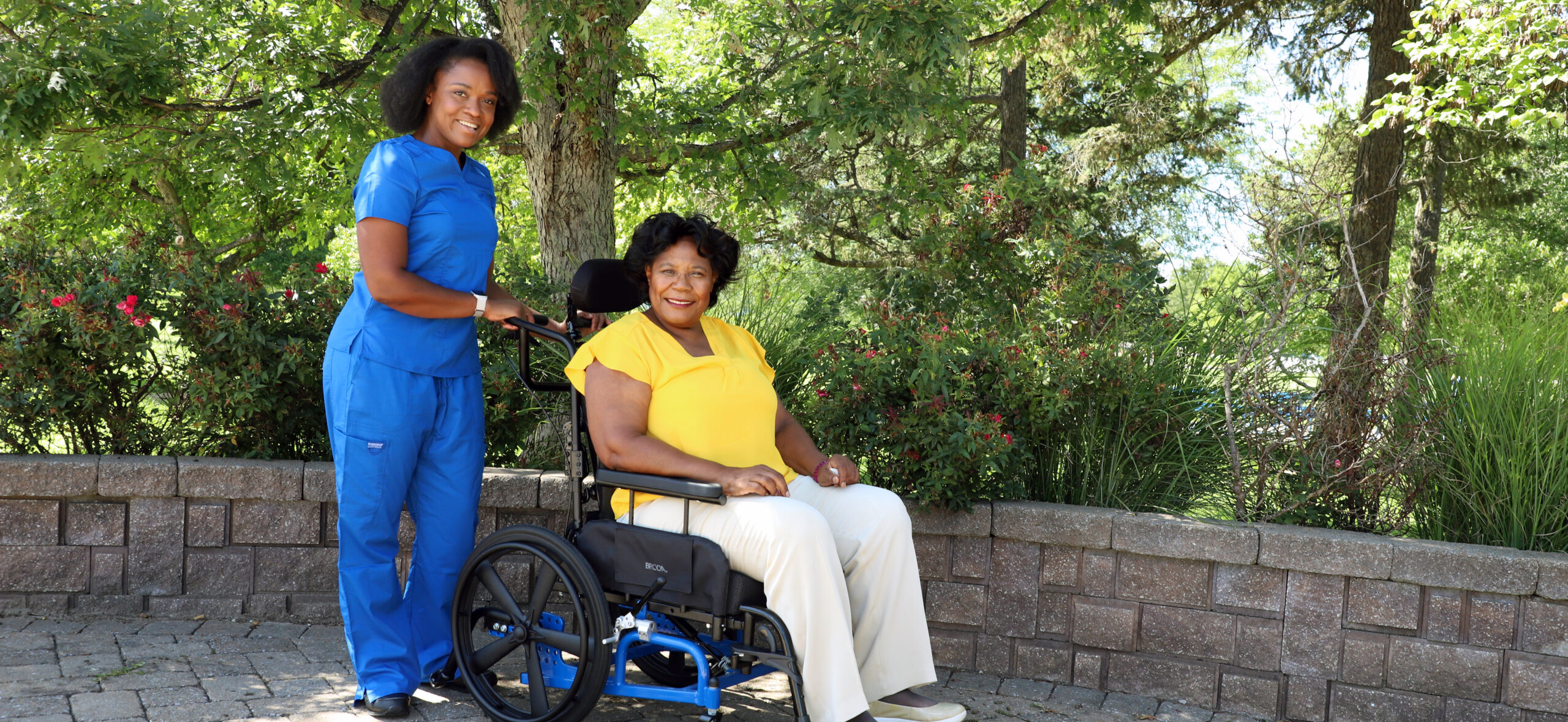 Hospice Nurse Standing Behind a Patient in a Broda Wheelchair