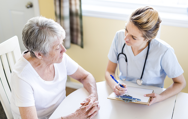 caregiver consulting with elderly patient
