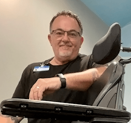 Mike McAdams poses with a wheelchair