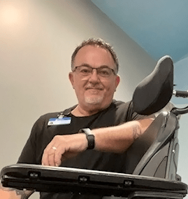 Mike McAdams poses with a wheelchair