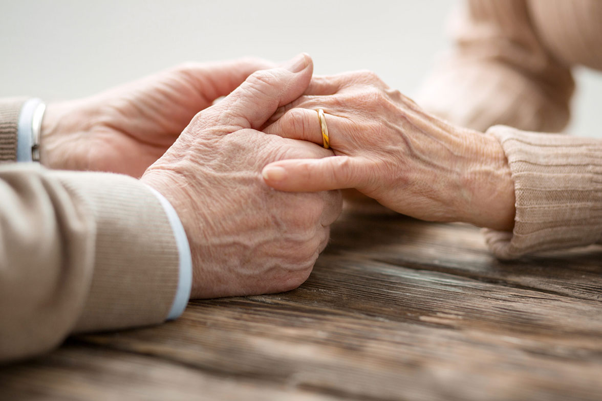 Aged married couple holding hands