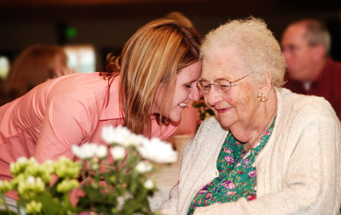 Elderly woman receives hug from daughter