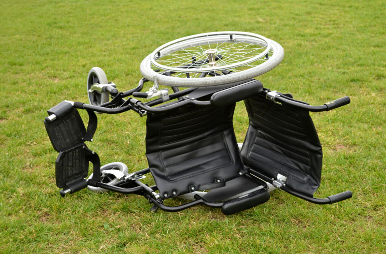 Empty Wheelchair On The Grass On Its Side