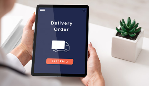 Person Holding a Tablet Displaying a Delivery Order Screen With a Tracking Button