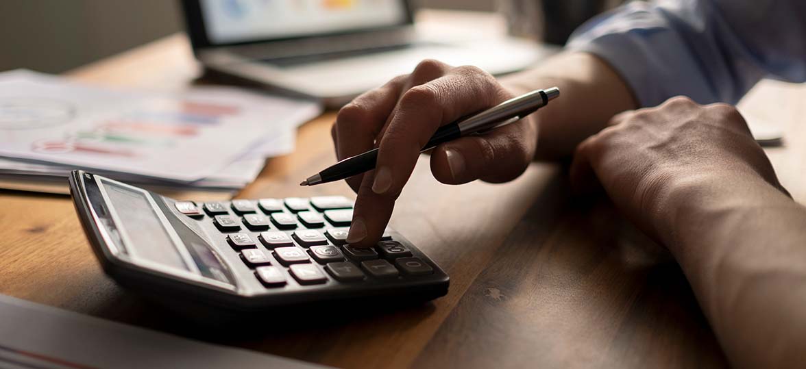 Close up of a person using a calculator at a desk