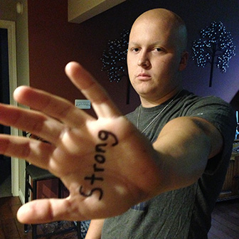 A young Tom Sikkema with "strong" written on his hand