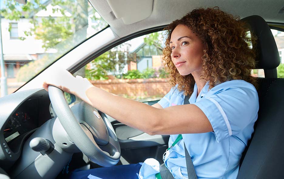 Young person in health care uniform driving