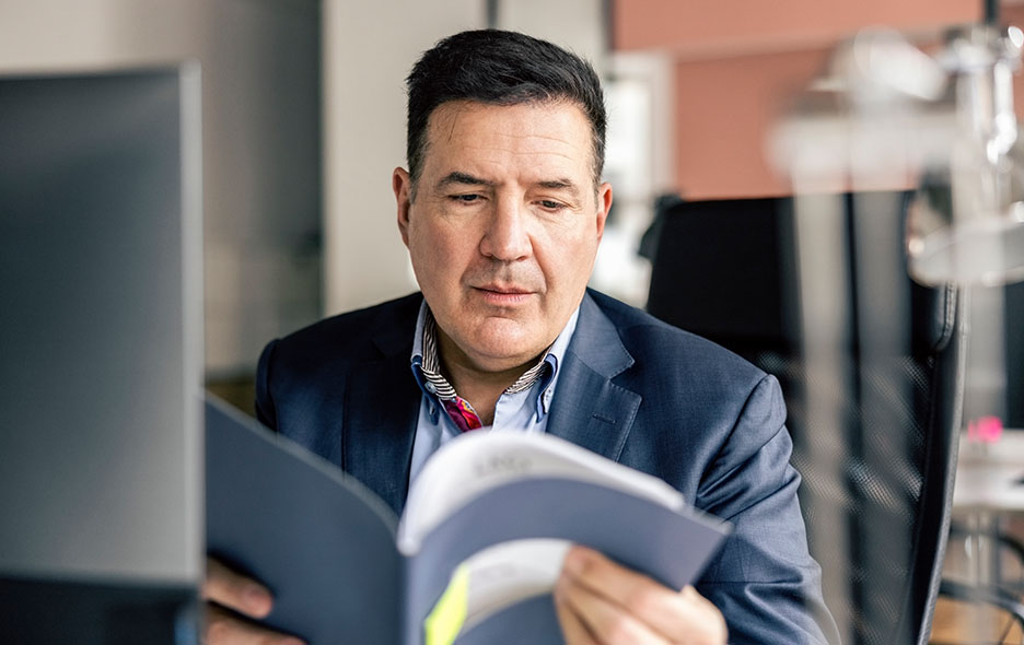 Business person looking over a folder of paper documents