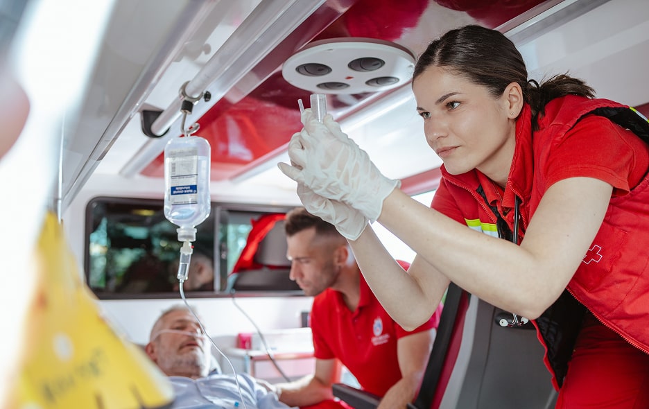 EMT's administering an IV in an ambulance