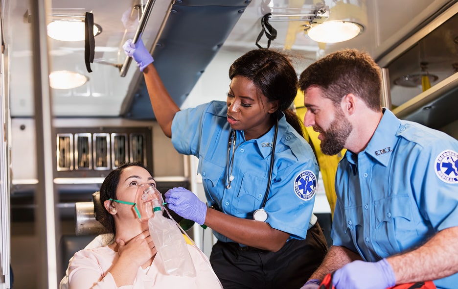 EMT's giving a patient oxygen in an ambulance