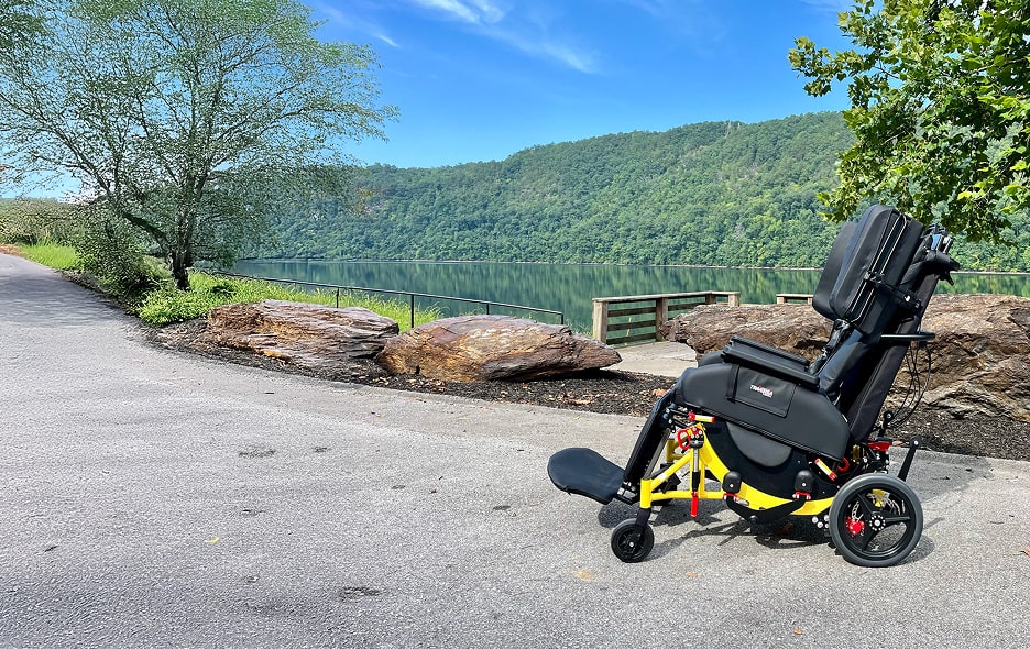 A Traversa NEMT chair on a walking path overlooking a lake