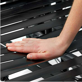 Close-up of a hand pressing down on the slatted seat of a chair