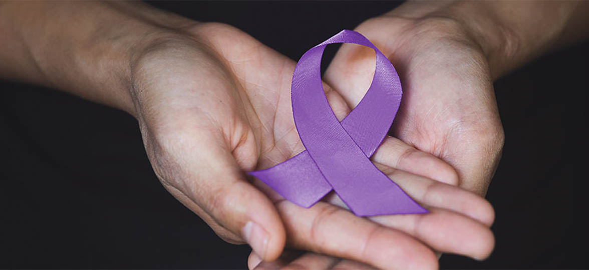 Close-up of hands holding a cancer awareness ribbon