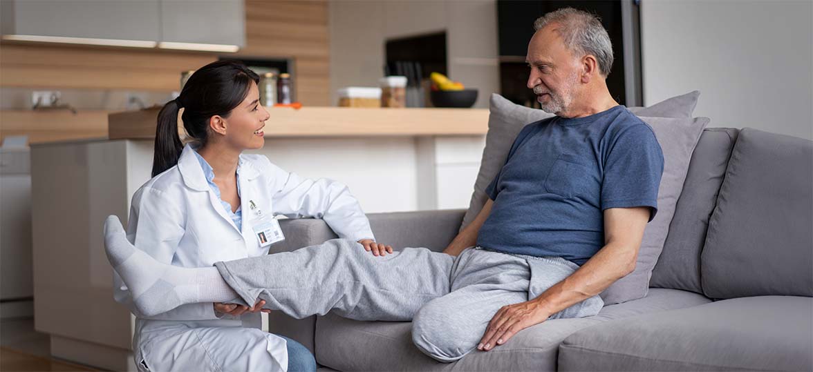 A senior man meeting within clinician on a house call to evaluate his limb functionality.