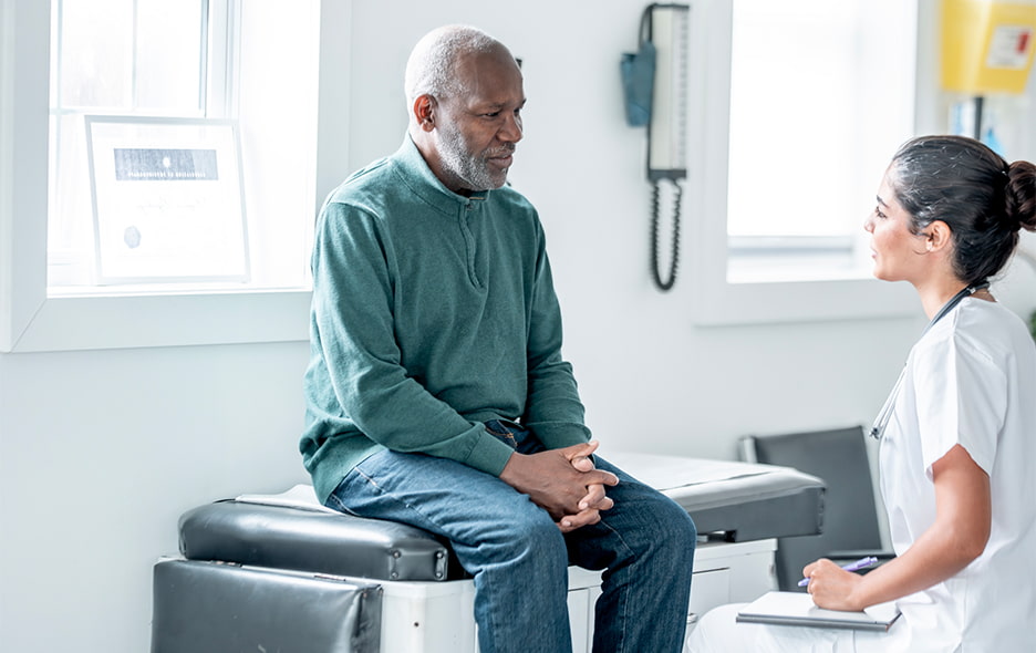 Senior man in a care facility while in discussion with a caregiver