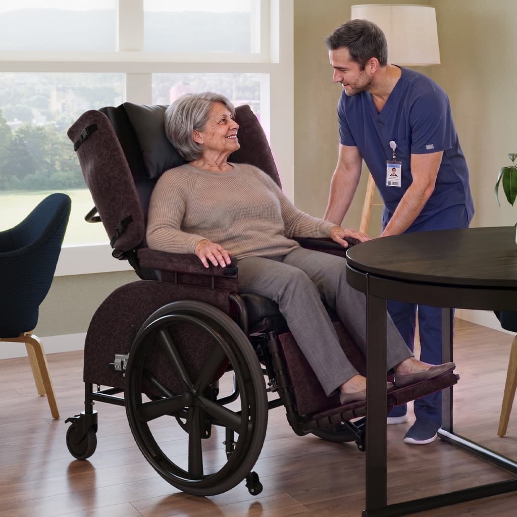Woman in a Midline Positioning wheelchair with a caregiver by her side