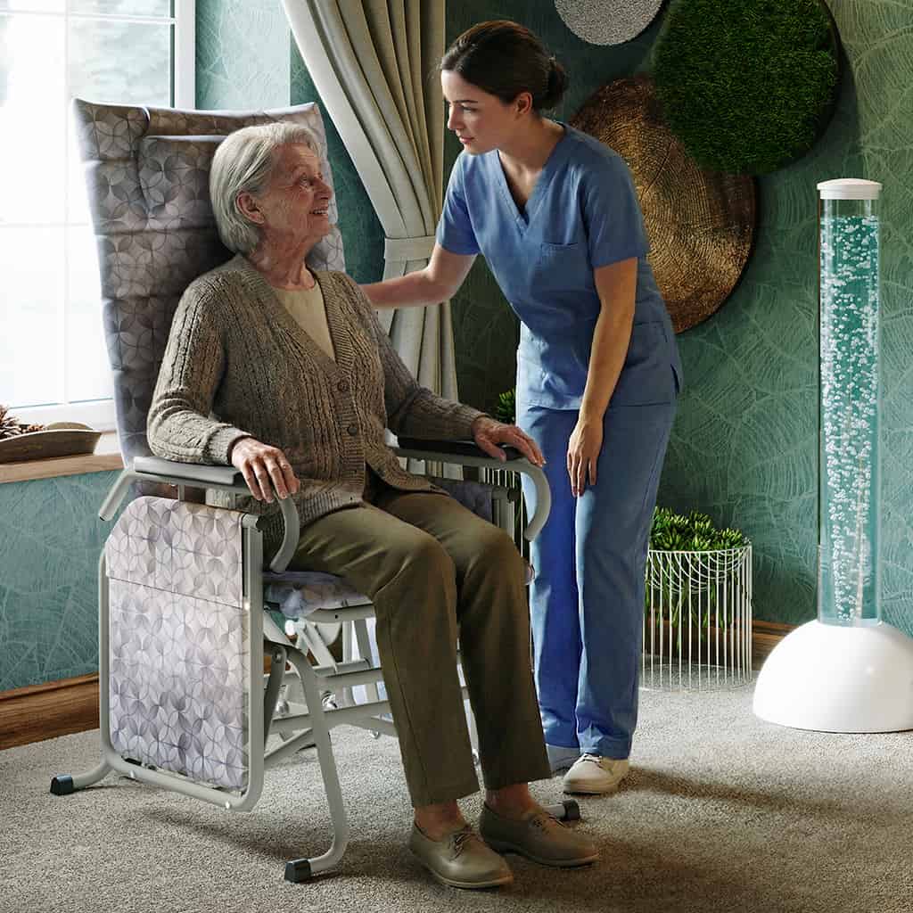 Senior woman in a glider interacting with a caregiver